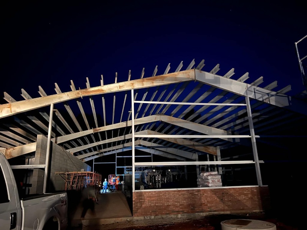 Nighttime steel truss erection under floodlights